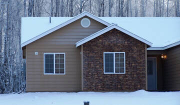 A stonewall tan veneer installed on a snowy home in Alaska