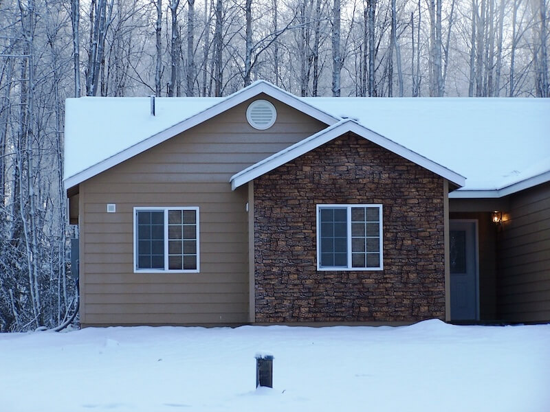 A stonewall tan veneer installed on a snowy home in Alaska