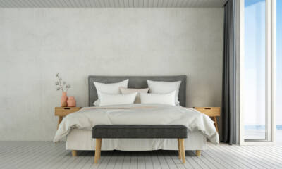 A modern bedroom with a concrete accent wall