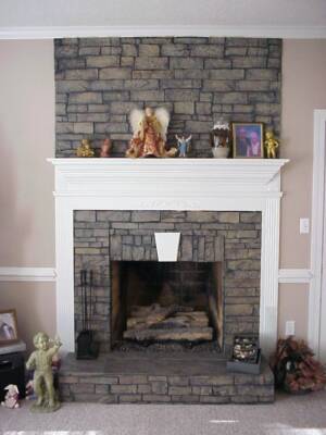 Fireplace with grey stone details and a white mantel. The mantelpiece displays a collection of figurines and a framed photo.