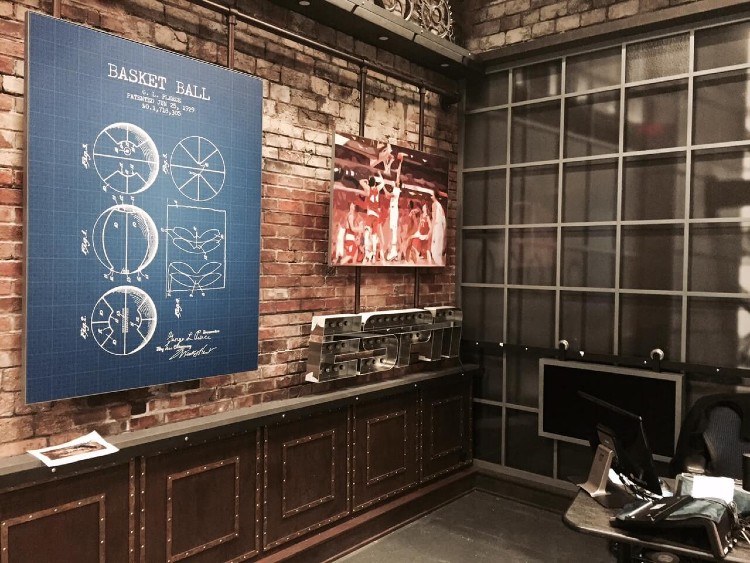 Corner of a television studio, featuring the ESPN logo and large prints against red brick faux wall panels.