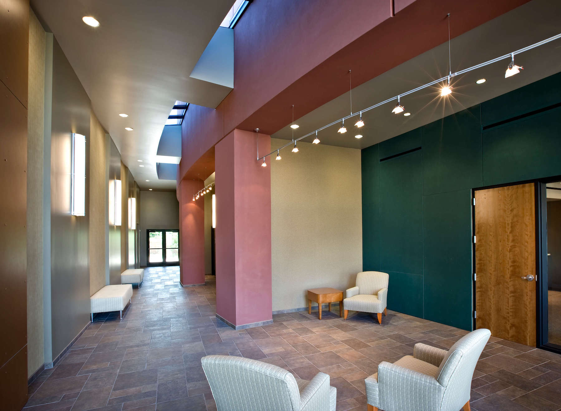 Office lobby with tile floors and a combination of cream, green and red walls.
