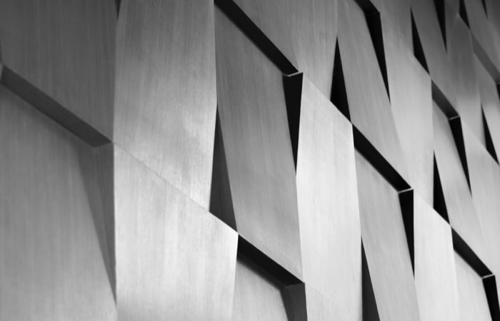 Geometric wall paneling of gray, offset squares.